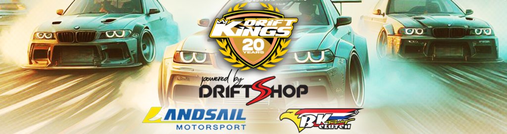 Grup de mașini de drift aliniate pe grila de start la o etapă Drift Kings, cu steaguri internaționale vizibile în fundal